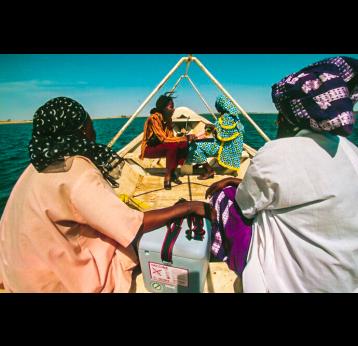 Health workers in Ghana doing immunisation outreach by boat. Credit: Gavi/2014/Thomas Kelly.